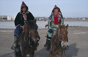 MONGOLIA, People, Buriyat ethnic minority couple in traditional dress riding horses with frosted