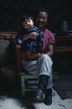 MONGOLIA, Children, Portrait of mother holding young child.