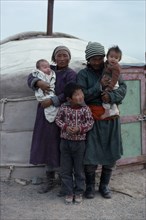 MONGOLIA, South Gobi, People, Family standing outside yurt.