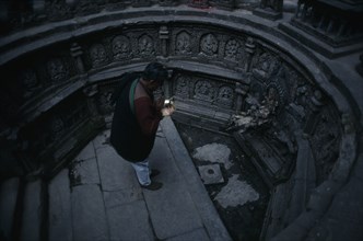 NEPAL, Kathmandu, "Man worshipping in sunken tank and former royal bath known as Tusha Hiti in