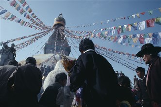 NEPAL, Bodhanath, "Crowds surrounding Bodhanath stupa hung with prayer flags during Loshar, the