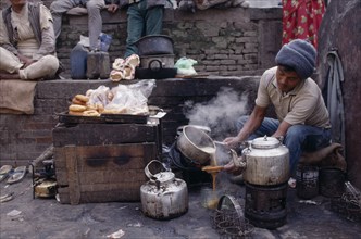 NEPAL, Markets, Food and Drink, Tea-wallah preparing tea boiled with milk and sugar and served in