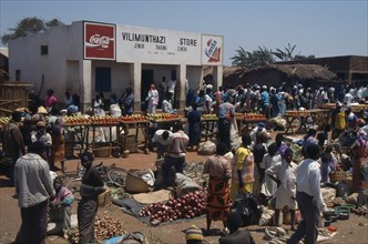 MALAWI, Jenda, "Crowded market scene, fruit and vegetable stalls with trading centre building