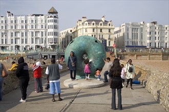 ENGLAND, East Sussex, Brighton, Tourists posing for photographs next to sculture on the seafront.