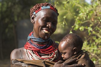 ETHIOPIA, Lower Omo Valley, "Mago National Park,", Karo woman holding baby