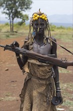 ETHIOPIA, South Omo Valley, Mursi Tribe, Woman with kalashnikov.