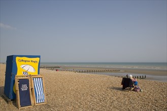 ENGLAND, West Sussex, Bognor Regis, Deck chair hire station on sand and shingle beach with a woman
