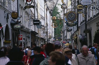 AUSTRIA, Salzburg, Crowds of shoppers on Getreidegasse with cafe and shop signs hanging from