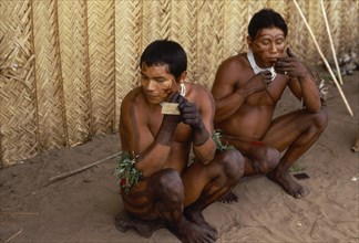 COLOMBIA, North West Amazon, Tukano Indigenous People, Barasana men applying dark red Achiote (from
