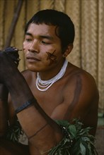 COLOMBIA, North West Amazon, Tukano Indigenous People, Barasana man looking in traded mirror to