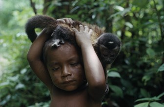 COLOMBIA, North West Amazon, Tukano Indigenous People, Portrait of young Makuna child with pet