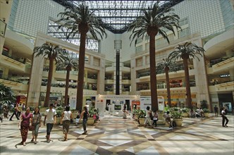 SINGAPORE, Raffles City, Interior of a shopping centre with palm trees.
