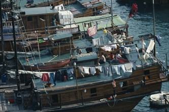 HONG KONG, Aberdeen Harbour, Sampan homes anchored in the harbour.  People and belongings on decks