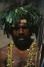 PAPUA NEW GUINEA, Goroka, Head and shoulders portrait of man wearing head-dress made from leaves