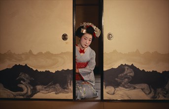 JAPAN, Customs, Geisha, "Portrait of Someiyu, a maiko or trainee geisha kneeling in tightly bound