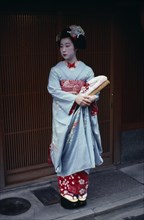 JAPAN, Honshu, Kyoto, "Someiyu, a maiko or apprentice geisha standing in the doorway of a geisha