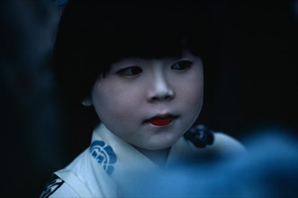 JAPAN, Honshu, Kyoto, Gion Festival.  Portrait of young girl with white painted face signifying