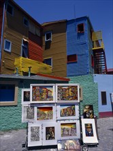 ARGENTINA, Buenos Aires, La Boca, Paintings on display with colourful architecture behind