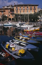 ITALY, Veneto, Lake Garda, Torre di Benaco.  Waterside buildings overlooking harbour with moored