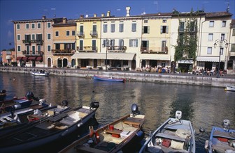 ITALY, Veneto, Lake Garda, Bardolino. Harbour scene with people at outside tables of waterside
