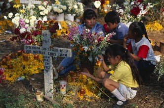 MEXICO, Michoacan, Patzcuaro, Tzurumutaro Cemetery.  Children by family grave decorated with