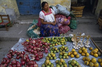 MEXICO, Guerrero, Markets, "Woman sitting behind street stall display selling onions, garlic and