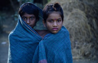 20088738 BANGLADESH Khulna Char Kukuri Mukuri Portrait of two young girls wrapped in turquoise fabric.