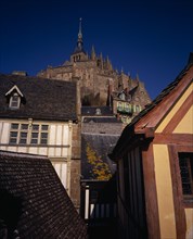 FRANCE, Normandy, Mont-St-Michel, The Abbey on hilltop above houses seen from Liberty Tower.