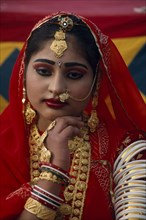INDIA, Rajasthan, Jaisalmer, Portrait of a Miss Desert contestant wearing red with traditional