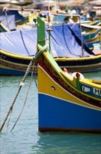 MALTA, Marsaxlokk , Fishing village harbour on the south coast with colourful Kajjiki fishing boats