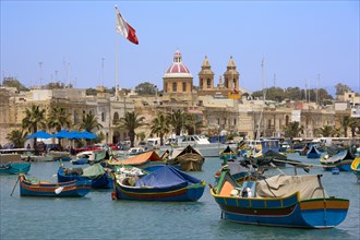 MALTA, Marsaxlokk , Fishing village harbour on the south coast with colourful Kajjiki fishing boats