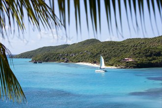 WEST INDIES, St Vincent & The Grenadines, Canouan, Raffles Resort Hotel with a catamaran leaving
