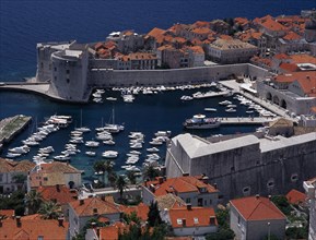CROATIA, Dalmatia, Dubrovnik, Elevated view over the Old City Harbour with fortified walls. Yachts