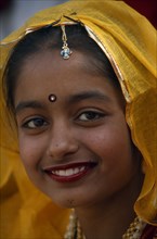 INDIA, Rajasthan, Alwar, Head and shoulders portrait of a young girl smiling at the Alwar Utsav