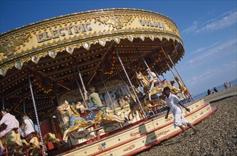 ENGLAND, East Sussex, Brighton, Children enjoying Carousel ride on Brighton beach