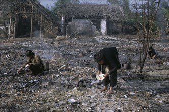 VIETNAM, North Central, Thanh Hoa, Woman trying to salvage items in bombed residential area.