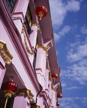 MALAYSIA, Penang, Georgetown, Pink and gold painted shopfront hung with red and gold Chinese