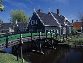 HOLLAND, Noord Holland, Zaanse Schans, Footbridge leading to a typical green wooden house in the