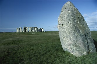 ENGLAND, Wiltshire, Stonehenge, View across the grass on Salisbury Plain toward the standing stones