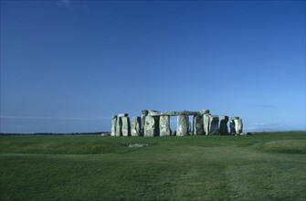 ENGLAND, Wiltshire, Stonehenge, View across the grass on Salisbury Plain towards the standing