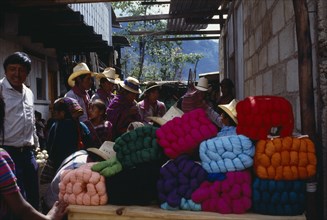 GUATEMALA, Todos Santos, Market scene with wool stall piled with brightly coloured bundles of wool