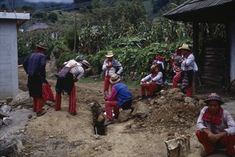 GUATEMALA, Todos Santos, "Group of men wearing traditional dress looking at recently dug drainage