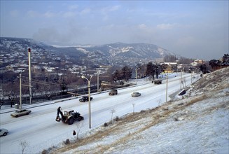 GEORGIA, Tbilisi, Cityscape and traffic in snow.