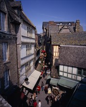 FRANCE, Normandy, Mont-St-Michel, "Looking down on narrow street, souvenir arcade and shoppers from