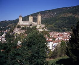 FRANCE, Midi-Pyrenees, Ariege, "Chateau Foix on hilltop above town with tree covered hillside