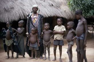 SENEGAL, People, Village queen standing with group of children.  She is believed to be a witch and