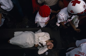 MEXICO, Mexico City, Woman being carried through crowd on stretcher by emergency services during