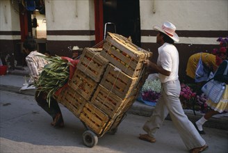 MEXICO, Guerrero State, Work, Traders using sack truck to transport wooden crates of fruit through