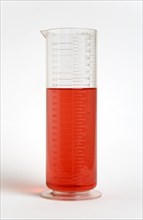 SCIENCE, Medical, Measurement, Plastic measuring beaker containing light red liquid and showing