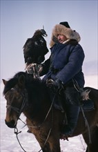 CHINA, Xinjiang, People, Kazakh horseman with hunting eagle on his hand.